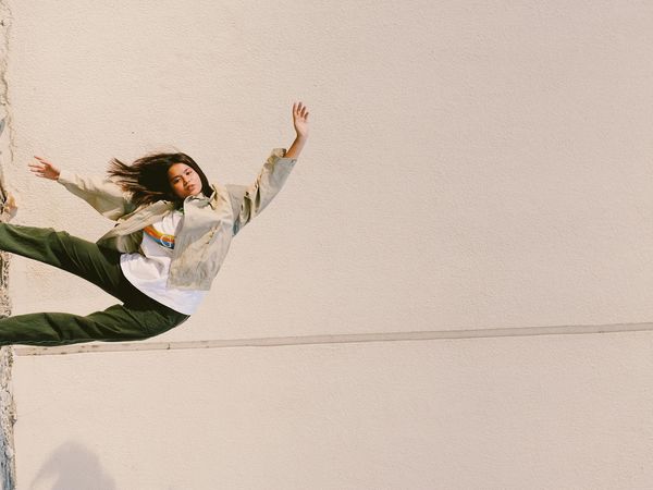 Person holding a challenging yoga balance pose against a minimal background.